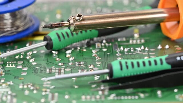 Video of an electrical circuit board with a soldering iron, solder,