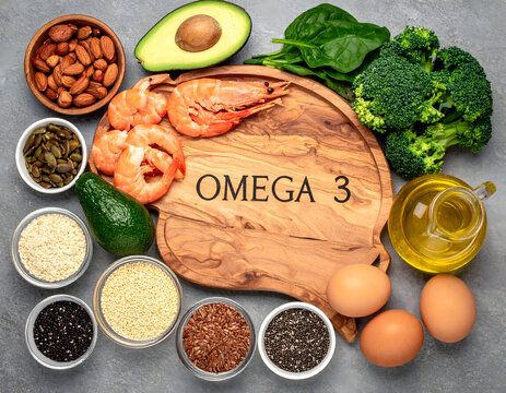Wooden brain-shaped board with 'OMEGA 3', surrounded by salmon, avocado, spinach, broccoli, nuts, seeds, olive oil and eggs; neutral background, natural lighting, photographic style.
