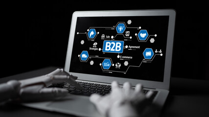 A sleek laptop showcases B2B e-commerce concepts with a robotic hand. The modern graphics highlight...