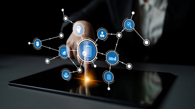 A business professional interacts with a digital touchscreen tablet, surrounded by application icons and data visualizations, showcasing modern technology in action. Tessel - Powered by Adobe