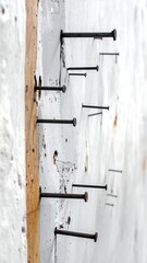 Nails protruding from wood, creating a textured pattern on a white surface.
