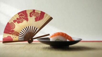 Enjoy sushi on a plate with a fan in the background during a sunny day in a Japanese setting