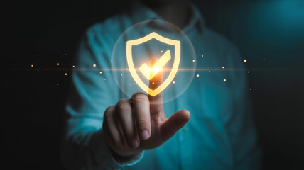 Person holding a glowing shield icon in a blue-lit room, symbolizing protection and security, with a futuristic and safe ambiance for cybersecurity concepts.