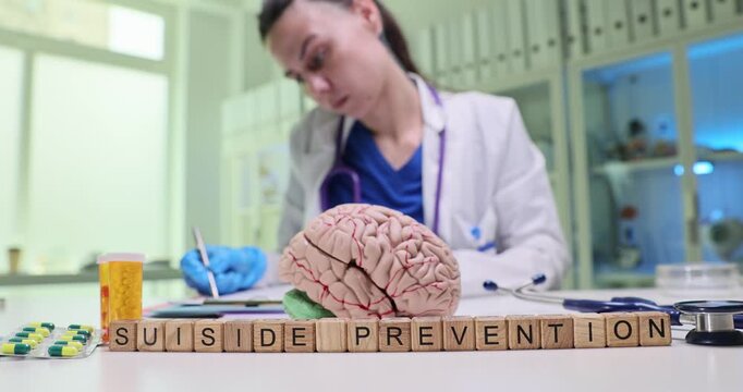 Wooden letter blocks form phrase Suicide Prevention. Psychiatrist writes recommendations aimed at reducing suicidal risk among vulnerable patients