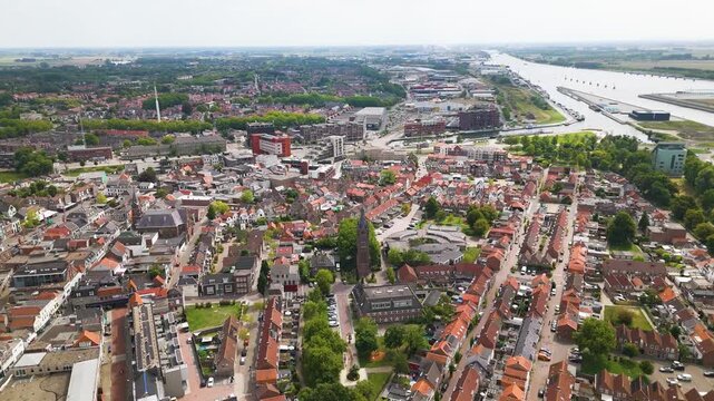 dense patchwork red tiled roofs historic brick buildings sits along curve industrial waterway cuts through landscape terneuzen port netherlands wide town red-tiled urban cityscape 
