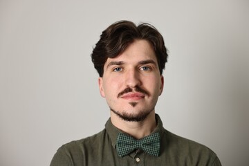 Obraz premium Handsome man with mustache on light grey background