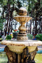 The photograph shows a fountain with water flowing out as a decorative element of a park in the village of Kabardinka, Russia.