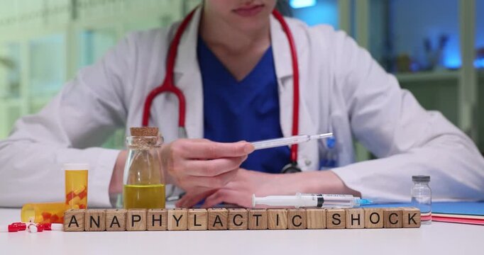 Wooden letter cubes on table form term Anaphylactic Shock. Doctor compares current temperature readings with previous measurements to assess trends