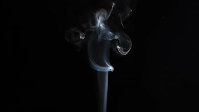 Smooth incense smoke swirls in a blue light pattern against a black background, creating an artistic wave of burning aroma and motion