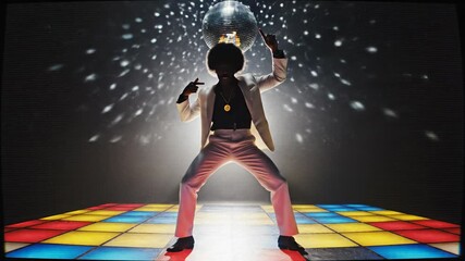 Silhouette of man dancing dynamically under disco ball on colorful dance floor. Energetic retro disco party vibe with sparkling lights and groovy pose capturing joyful movement sequence