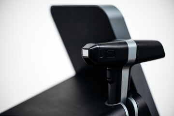 Advanced RF lifting device for cosmetic dermatology positioned on a sleek treatment chair in a modern beauty clinic with minimalistic design and neutral color palette