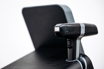 Advanced RF lifting device for cosmetic dermatology treatment, featuring ergonomic handle and sleek design, positioned on a modern beauty clinic chair with minimalistic background