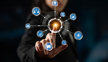 Fototapeta premium A business professional interacts with a futuristic touchscreen interface showcasing various digital icons, symbolizing technology and modern innovation in a corporate setting. Crux
