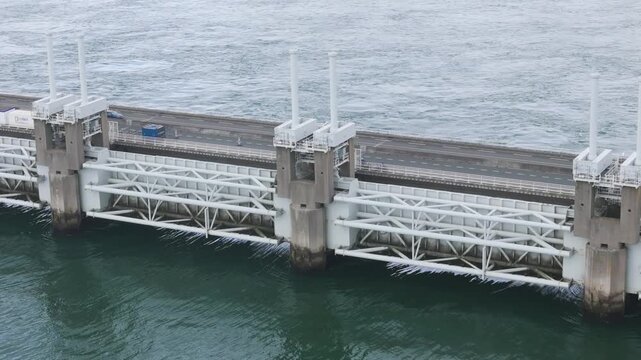 intricate white metal supports massive concrete foundations visible eastern scheldt storm surge barrier against tides netherlands aerial view delta works flood protection 