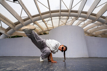 Woman performing a hip hop dance pose outdoors with confident expression