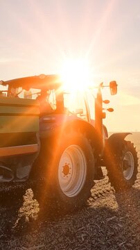Farmer with agricultural machinery fertilizing wheat field in winter time at sunrise, slow motion. Spreading mineral fertilizer, landscape rural scene