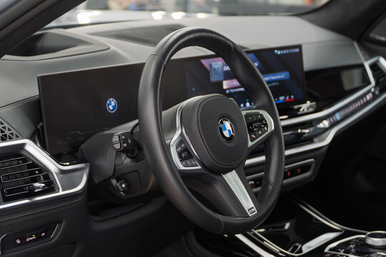 BMW X7 I (G07) M50d, Vehicle leather interior SUV car. Interior of modern car with dashboard, media system control panel, shift gear. German premium SUV car. BMW logo on the dashboard. 