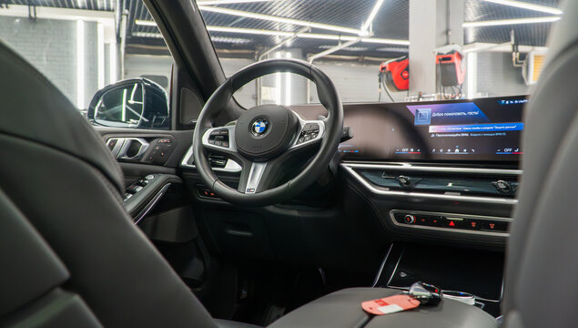 BMW X7 I (G07) M50d, Vehicle leather interior SUV car. Interior of modern car with dashboard, media system control panel, shift gear. German premium SUV car. BMW logo on the dashboard. 