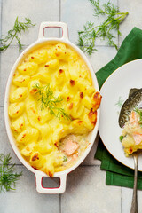 Shepherd's pie with salmon, green peas, mashed potatoes baked in a pan.