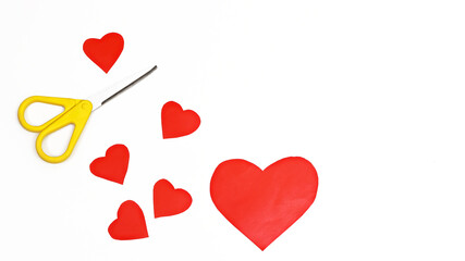 Red paper hearts and yellow scissors on white background, DIY concept for Valentines Day