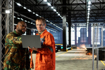 Diverse military officer and staff managing production adapted for armament manufacturing,...