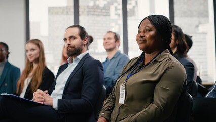 International business forum with panel and guest speaker. Audience of diverse people applauding and interacting during speech. Conference hall with shareholders and participants.