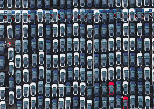 Aerial view of densely parked vehicles at port terminal.