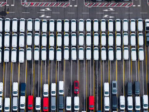 Aerial view of densely parked vehicles at port terminal.