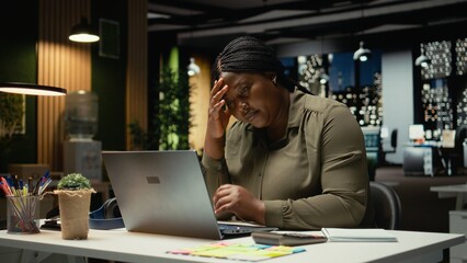 Female entrepreneur sighing being drained and overwhelmed after hours, pushing limits despite clear signs of fatigue and tension. Workplace challenges and discouragement bring discomfort. Camera A.