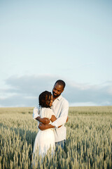 Happy romantic couple hugging in a summer field