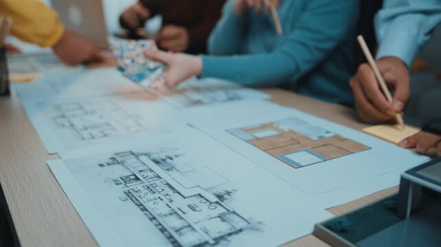 A diverse group of professionals collaborates on architectural blueprints in a modern office environment, showcasing teamwork, creative brainstorming, and project planning. SACTR