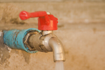 Red Water tap with water flowing