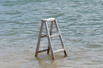 Wooden Ladder Standing Alone in Shallow Water of Calm Sea Environment