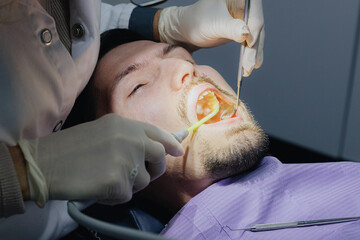 A young Caucasian patient undergoes a dental examination in a dental office.