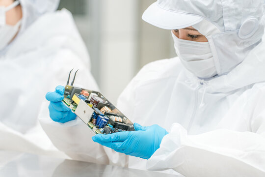 A woman working with precision equipment in a clean room