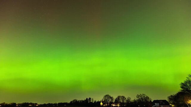 A spectacular time lapse sequence of the Aurora Borealis (Northern Lights) illuminating the night sky near Hamburg, Germany. 
The long-exposure photograph captures intense shades of green and rare red