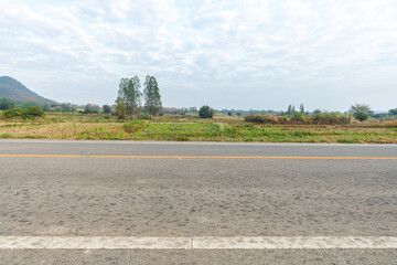 Side view of asphalt road with the meadow. Road background.