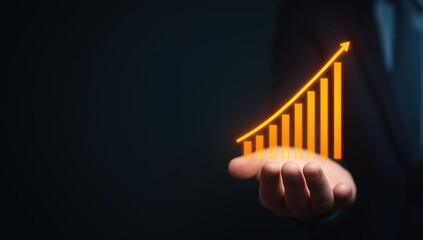 Hand presenting a glowing orange bar graph and curved arrow showing increasing financial success and positive business development