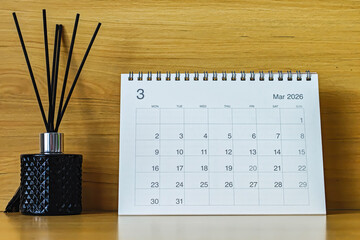 Office desk calendar showing March 2026 with copy space on wooden background, ideal for business planning, scheduling, and time management concepts.