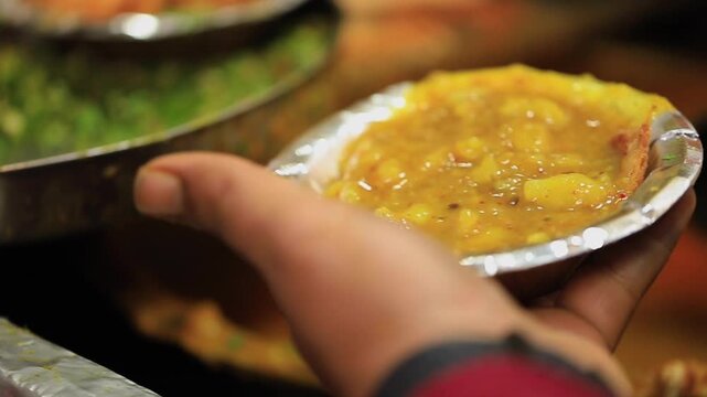 Closeup shot of serving aloo sbji in bowl. Indian street food.