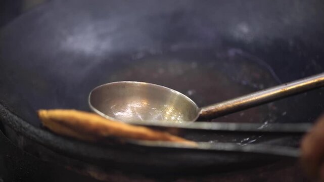 Closeup shot of deep frying Indian bread in oil.
Delhi famous street food.