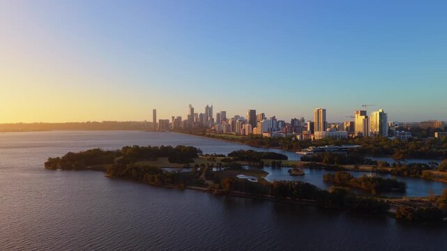 Drone rising over Herisson Island at sunset with Perth CBD in the background