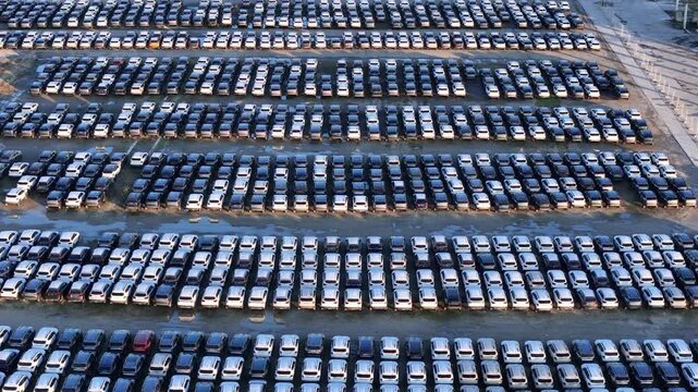 Drone view shows imported cars parked in parallel rows within a logistics storage yard, emphasizing automotive distribution, fleet management, transport efficiency, and large scale vehicle handling.