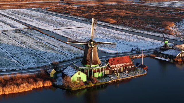 Aerial winter view of the Zaanstreek windmills at Zaanse Schans, showing historic polder mills, snow landscape, and Dutch cultural heritage.