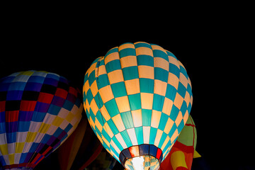 colorful hot air balloons glowing against dark night sky