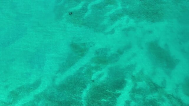 4k drone footage of beautiful clear blue ocean on waimanalo beach panning up to Olomana mountain and the Koolaus on Oahu Hawaii