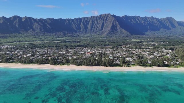 4k drone footage of beautiful clear blue ocean on waimanalo beach dolly left to reveal Waimanalo town and koolaus in background