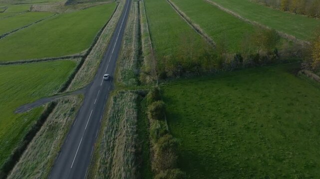Hvalfj&ouml;r&eth;ur Iceland road trip green grass landscape, aerial drone car follow-up