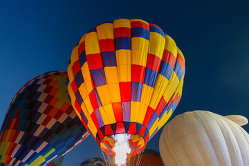 colorful hot air balloons glowing against dark night sky