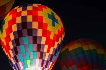 colorful hot air balloons glowing against dark night sky